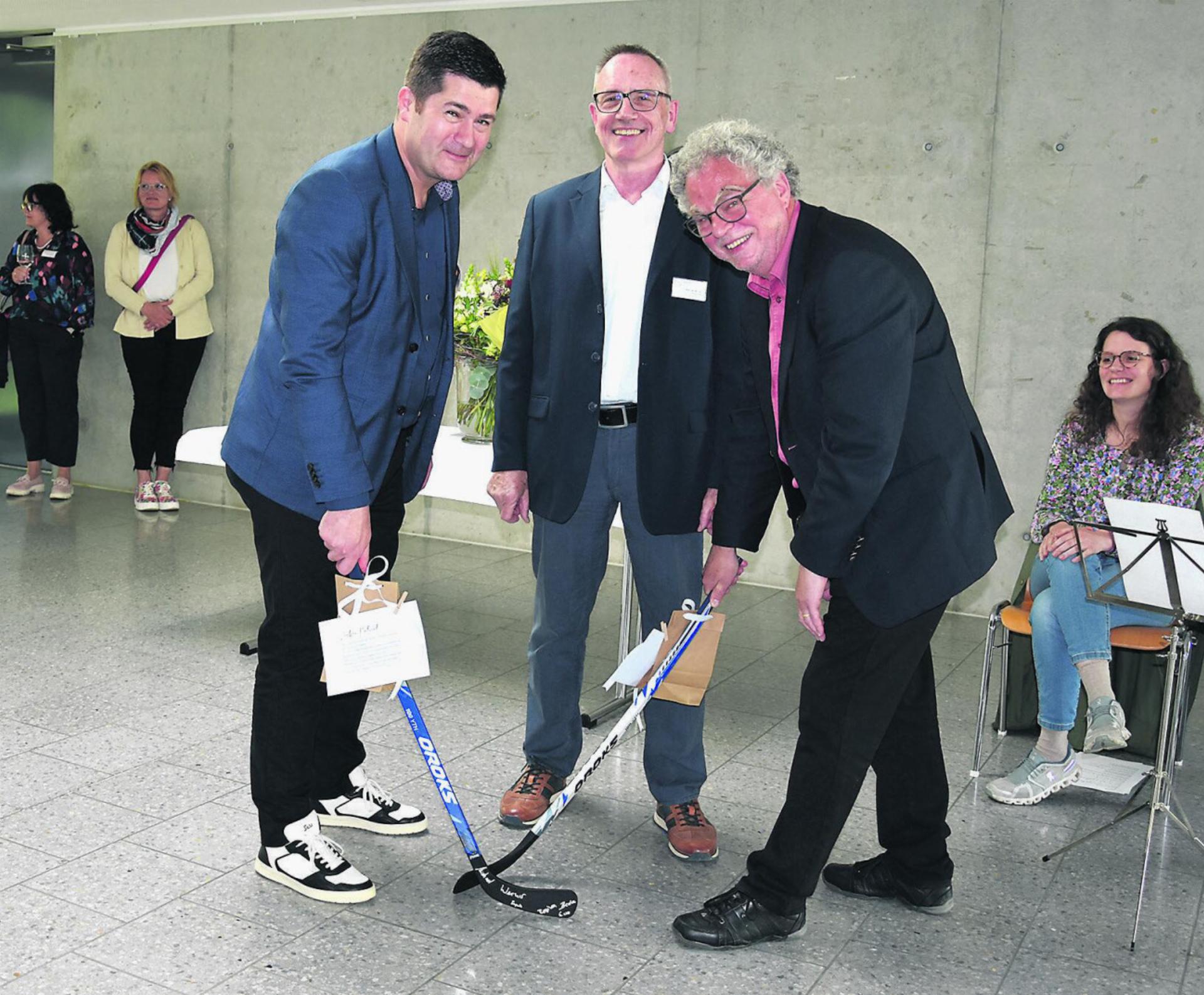Vereinspräsident Werner Müller überreichte dem neuen VAOF-Geschäftsleiter Patrick Hüsser (links) und Andre Rotzetter einen Hockeyschläger. Beide sind Eishockey-Fans. Foto: Susanne Hörth
