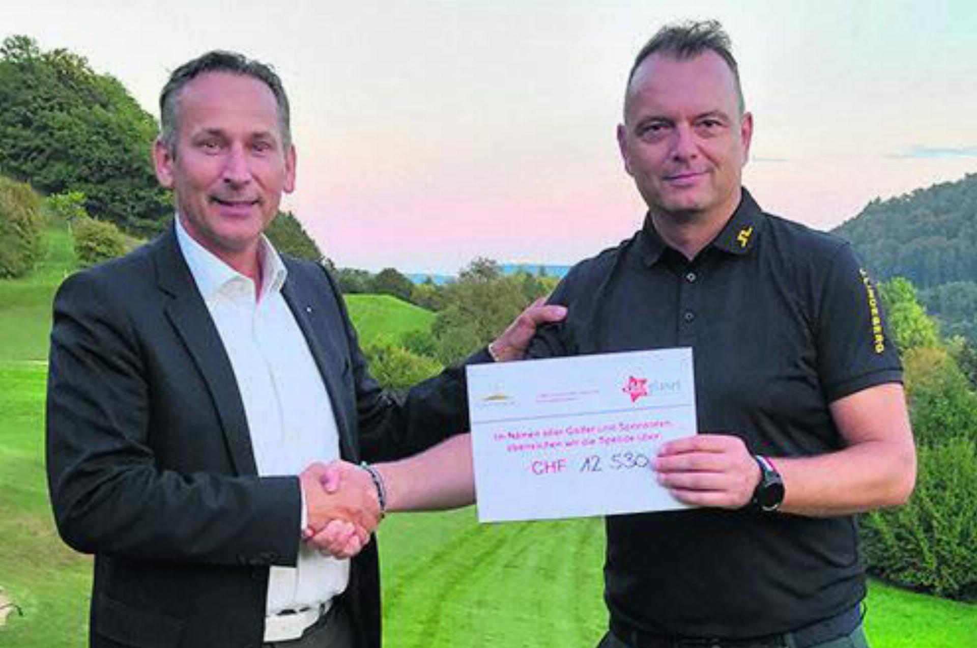 Golf Fricktal-Manager Silvan Barbui überreicht Thomas Denzler einen Check für «kidz planet». Foto: zVg