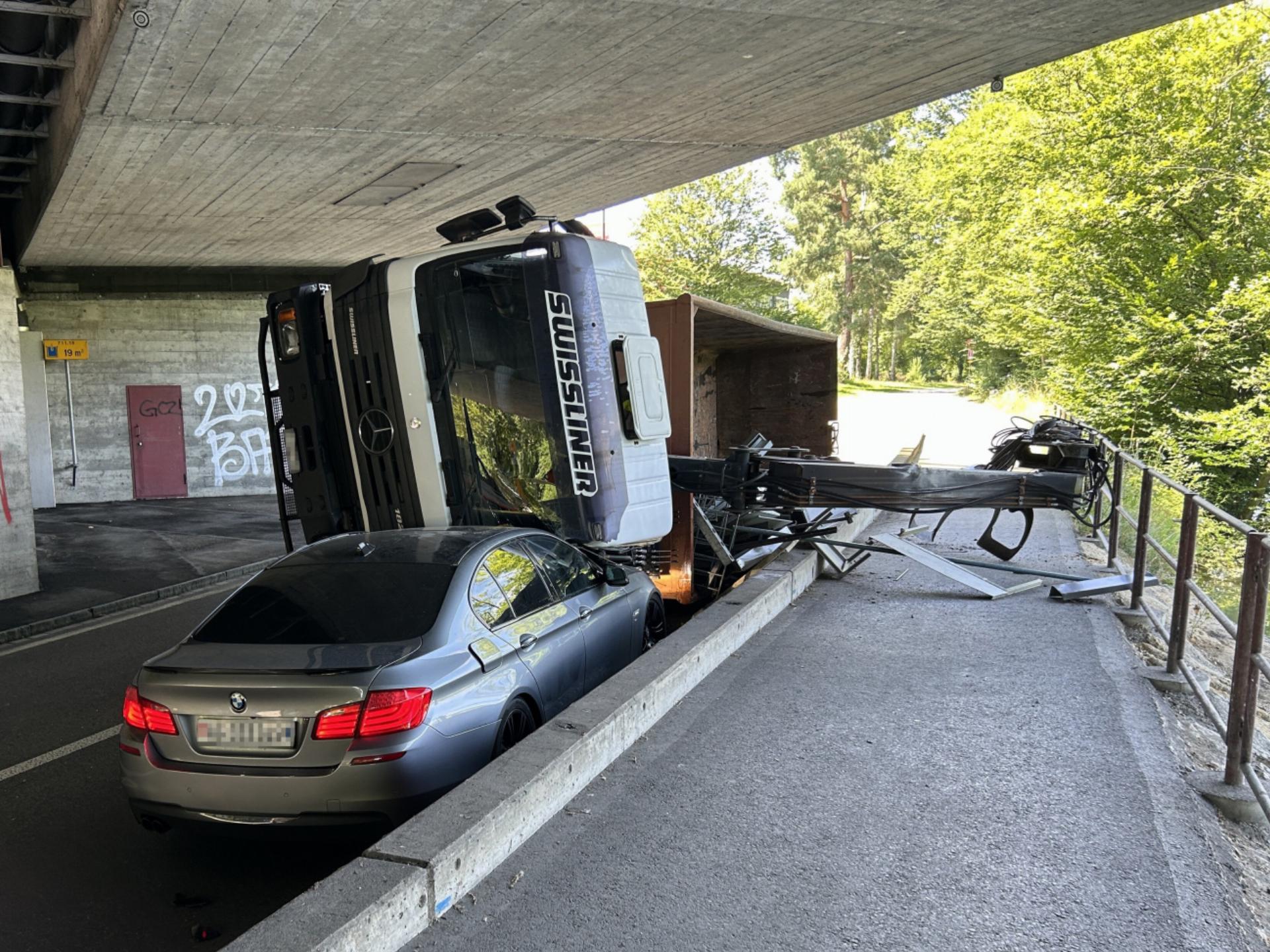 Lastwagen mit ausgefahrenem Kran kracht in Autobahnbrücke