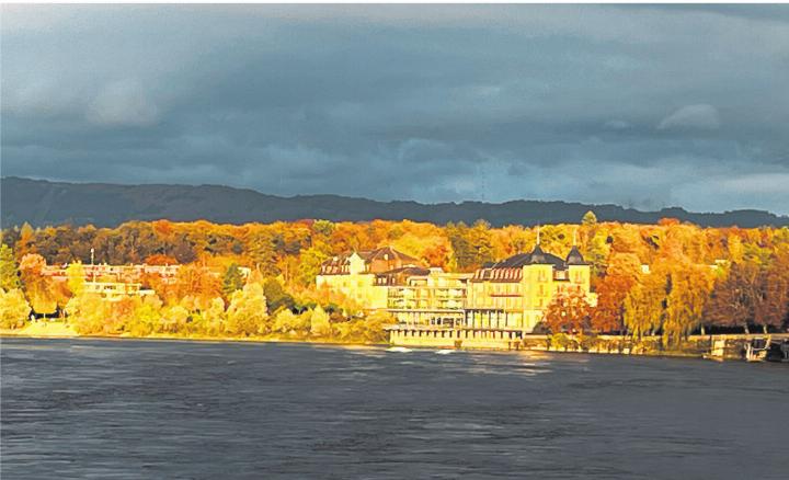 Erleuchtet: Der Rheinfelder Stadtpark und das Park-Hotel erstrahlen in der Sonne, während der Himmel und der Rhein einen dunklen Kontrast bilden. Foto: Valentin Zumsteg