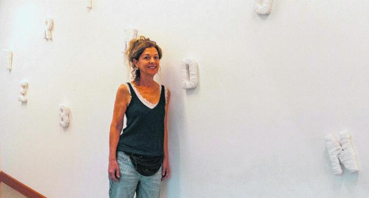 Die Künstlerin Dora Freiermuth umgeben von Buchstaben, die den Ausstellungstitel «VERBINDUNG» ergeben. Foto: Jean-Marc Felix