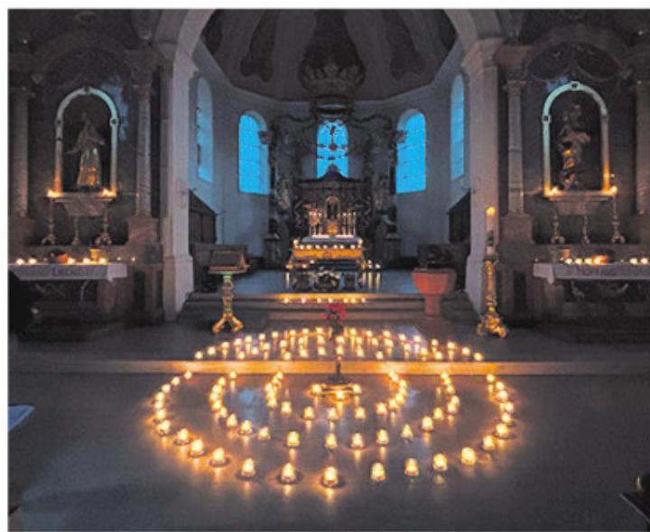 Der Kirchenraum erhellt vom warmen Schein der Kerzen. Foto: zVg