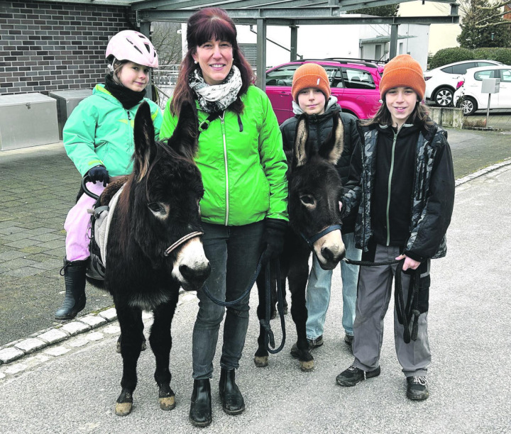 Spaziergang durchs Dorf: Corinne Reichenstein mit den Kindern Valentina (von links), Nicolas und Michel und den Eseln Thor und Merlin. Foto: Janine Tschopp