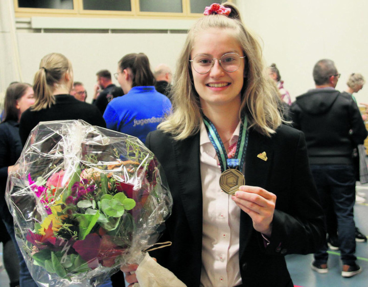 Vera Stocker mit Blumen und dem «Medaillon for Excellence» erlebt einen warmen Empfang in Wegenstetten. Foto: Hans Zemp