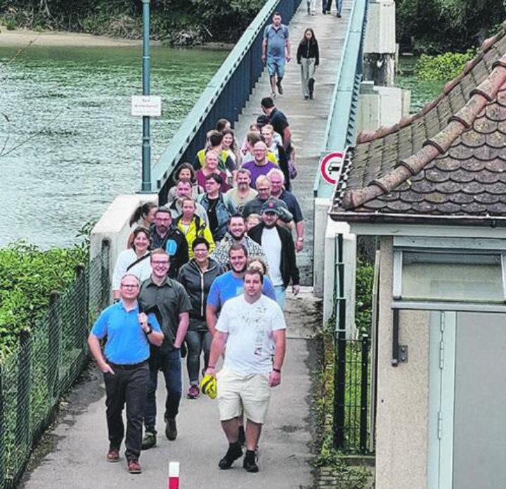 Die Helferinnen und Helfer des Fisch essens überqueren die Zollbrücke. Foto: zVg