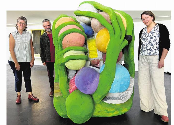 Die Kuratoren Nina Wakeford (von links) und Michael Hiltbrunner mit Patrizia Solombrino, Geschäftsführerin Rehmann-Museum, mit dem Objekt «L’idiot vert» (1984) von Peter Fischli und David Weiss. Foto: Charlotte Fröse