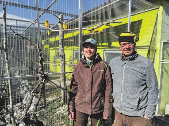 Noemi Appert und Rolf Lanz vor der Voliere der Goldsittiche, eine bedrohte Art, die aus Südamerika stammt, und im Rahmen des Artenschutzprogramms im Vogelpark gezüchtet wird. Foto: Sonja Fasler