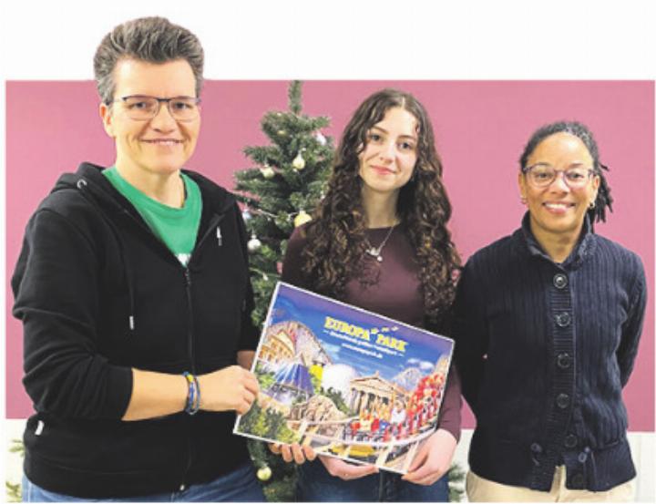 Amira Ferrari (Mitte), die Gewinnerin des Zeichnungswettbewerbs, erhält im Beisein von Mary Anne Dillier, Lehrperson an der Oberstufe Kaiseraugst (rechts) einen Wertgutschein für den Europapark. Foto: zVg