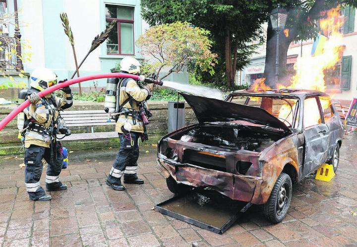 Die Feuerwehr-Leute bekämpfen einen Fahrzeug-Brand mitten im Städtli.